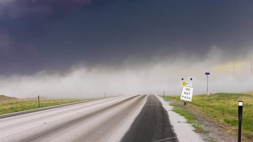 Staubwolken wehen bei Sturm schnell über eine Straße