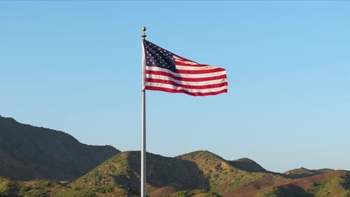 American Flag Waving Proudly Against Blue Sky