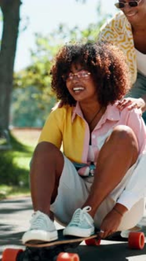 Laughing, couple and push on skateboard at park with support, bonding activity or street fashion