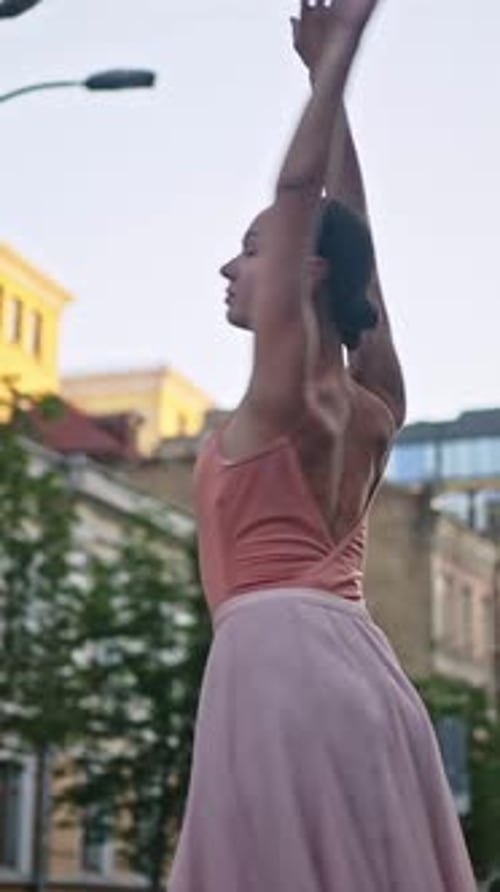 Jeune ballerine écarte les mains en dansant le ballet dans la rue