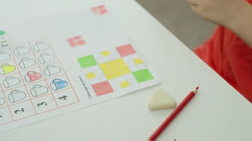 O menino escolhe um lápis verde para completar a tarefa