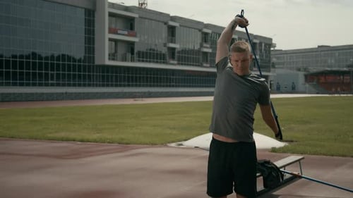 Para-Athlete with Missing Hand Stretching Chest with Elastic at Outdoor Stadium