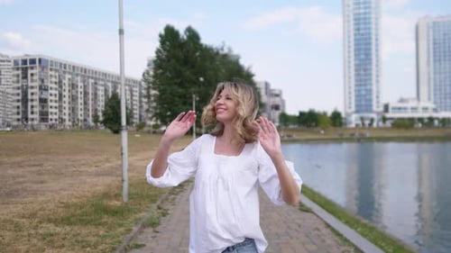 Beautiful Happy Woman Walking Along the Footpath in the Park