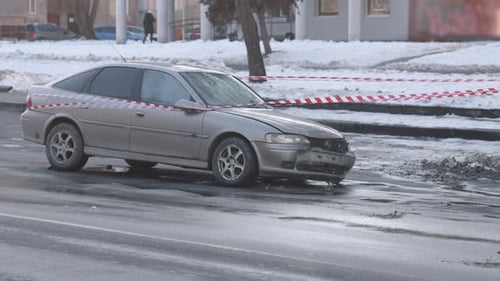 Damaged Car at Accident Scene with Police Tape