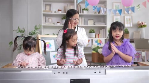 Woman Teaching Children to Play Electronic Piano