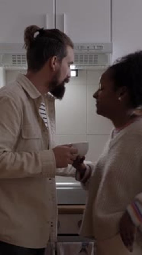 Young Couple Sharing Coffee in Kitchen Together