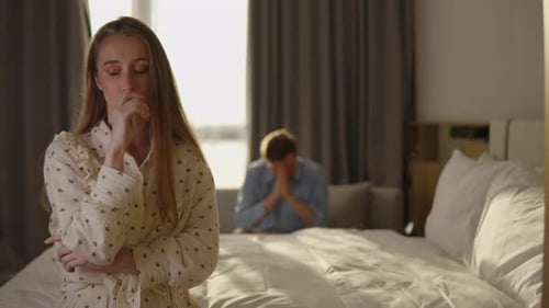 Heartbroken Woman Realizing Betrayal Standing in Shock While Her Guilty Boyfriend Sits Behind