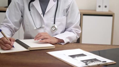 Doctor Writing Notes in Medical Office Setting