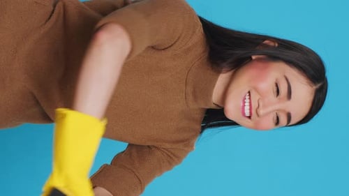 Smiling Woman Cleaning With Sponge and Gloves