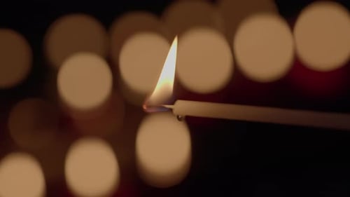 Burning Candle Flickering in the Dark Night