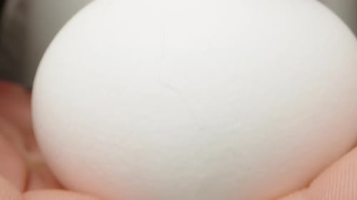 Die junge Frau zerbricht und gießt das Ei ein. Dolly Slider extreme Nahaufnahme
.