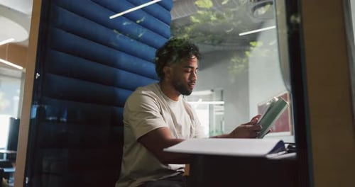 Man, research and tablet in office pod for creative project, editor feedback or article review