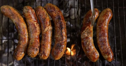 Delicious juicy sausages, cooked on the grill with a fire.