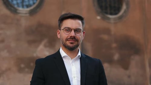 Handsome Businessman Wearing Glasses Standing City at the Background and Smiling Broadly at the