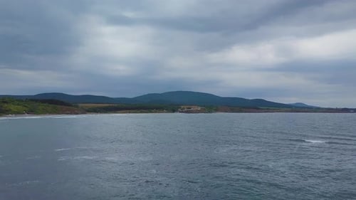 Drone flying above sea to the beach in winter