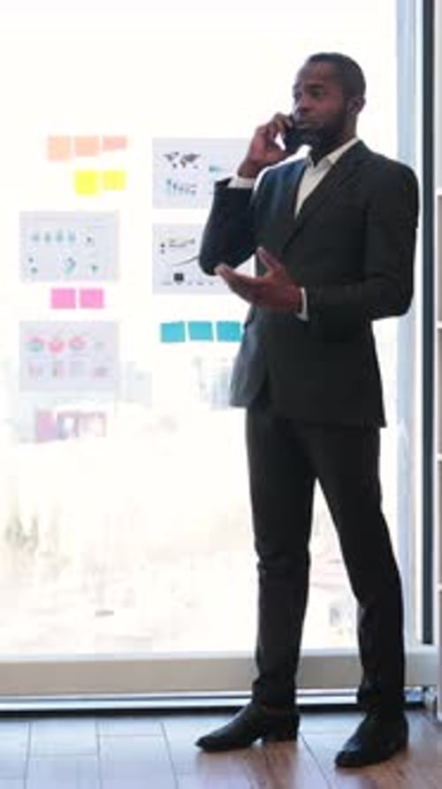 Businessman on Phone Near Charts