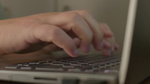 fingers typing on laptop keyboard