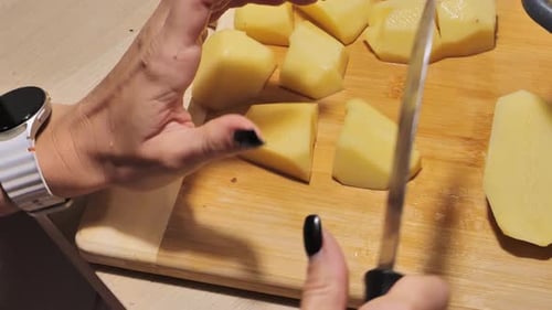 Slicing Potatoes on Wooden Cutting Board, Detailed Cooking Process, Handheld Shot