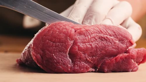 Fresh Raw Beef Being Sliced with Knife