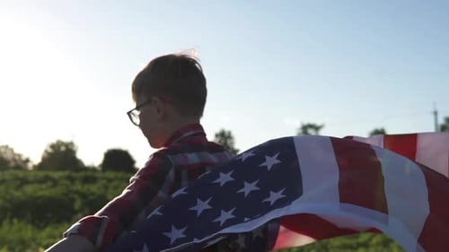Child Walks With American Flag on Sunny Day