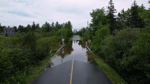 Flooded road closed due to climate change natural disaster submerging bridge