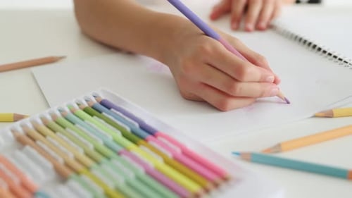 Child Drawing with Colored Pencil on Paper