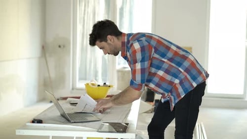 Young Man Designs Renovation Project On Laptop