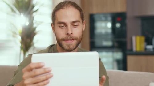Young Adult Man Using Tablet at Home