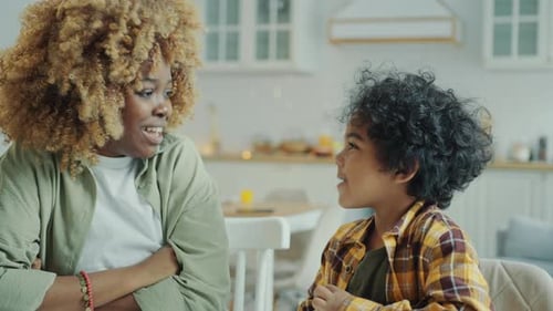 Woman Talks with Child in Kitchen Setting