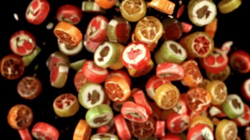 Colorful Candies with Fruit Designs Falling on Black Background