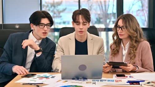 Business meeting in an office, female team leader and two young workers discussing business affairs