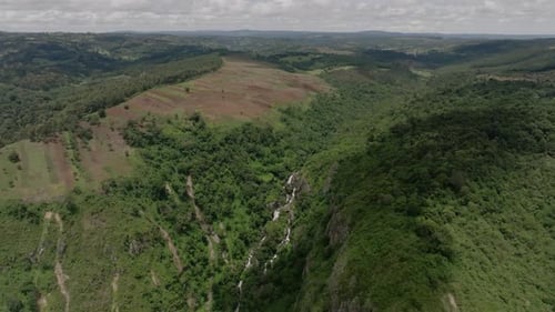 Aerial view of the Keiyo Valley with a waterfall and lush green hills, Kenya.