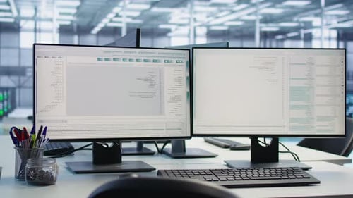 Dual Monitors Displaying Software Code in Modern Corporate Office