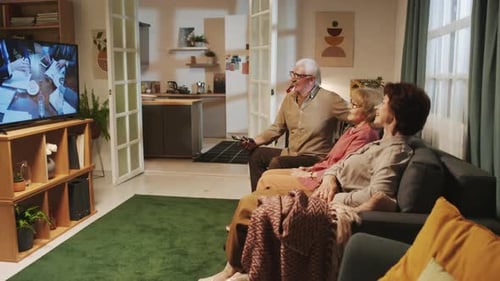 Seniors Watching Television Together on Couch at Home