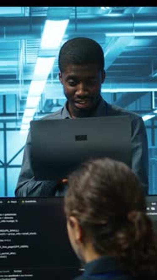 Two Adults Collaborating on Code in Office Environment