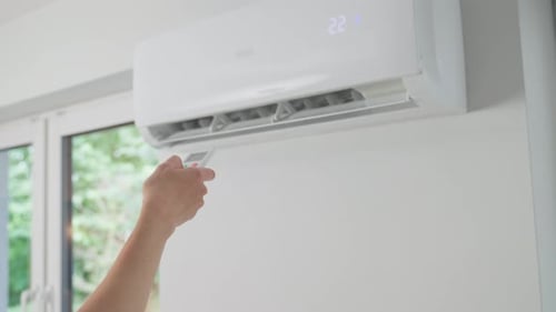 Adjusting Air Conditioner with Remote Control in Home