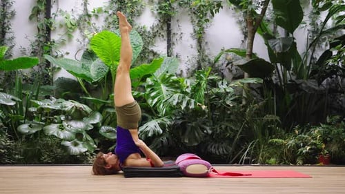 Woman Doing Shoulder Stand Yoga Pose Indoors