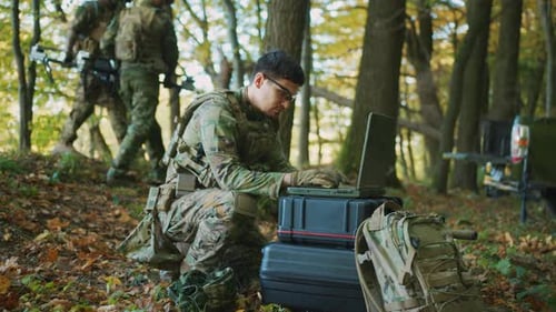 Fighter in Military Uniform Using Laptop Computer for Drone Controlling Surveillance During Military