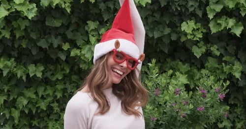 Cheerful Woman Wearing Santa Hat and Festive Glasses