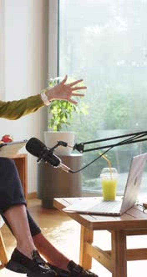 Vertical video: Diverse women hosts on set, tablet cueing host while Asian woman replying by mics