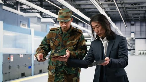 Two Men Examining Microchips in Modern Factory
