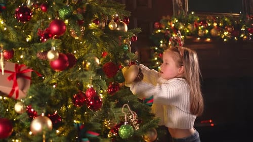 Merry Christmas Xmas Holiday Little Girl Decorating Christmas Tree on Christmas Eve at Home Young