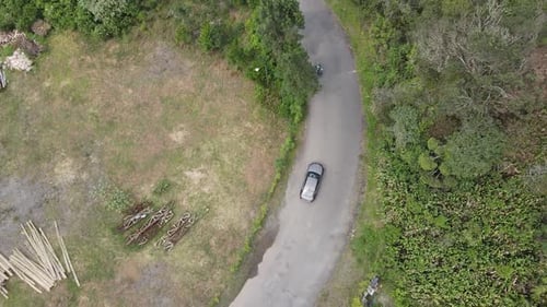 Drone tilt up: aerial view of highway on the hill with passing vehicle