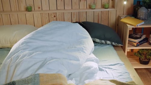 Man Lying in Bed, Covering Himself with Pillows