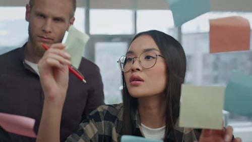 Creative Team Brainstorming Sticker Wall Office Close Up. Hipster Multiethnic Couple Talking