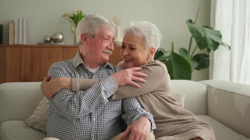 Loving Senior Couple Embracing on Sofa