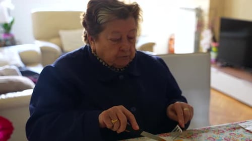 Close up shot of a senior woman enjoying an orange at home, zoom in