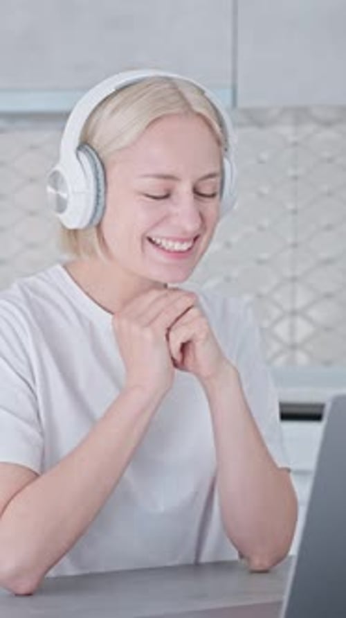 Woman with headphones in video call at home