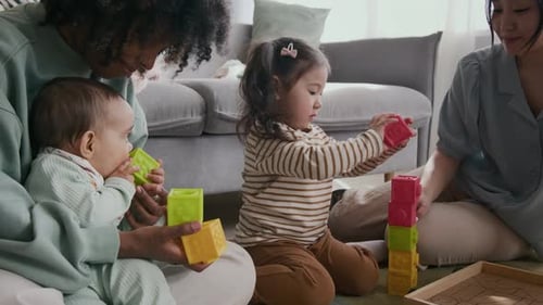Child Putting Toy Cubes on Top of Each Other while Building Tower