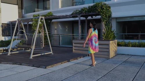 Asian Woman Walking at Outdoor Terrace in Sunset Light At Luxury Hotel In Uluwatu, Bali, Indonesia.